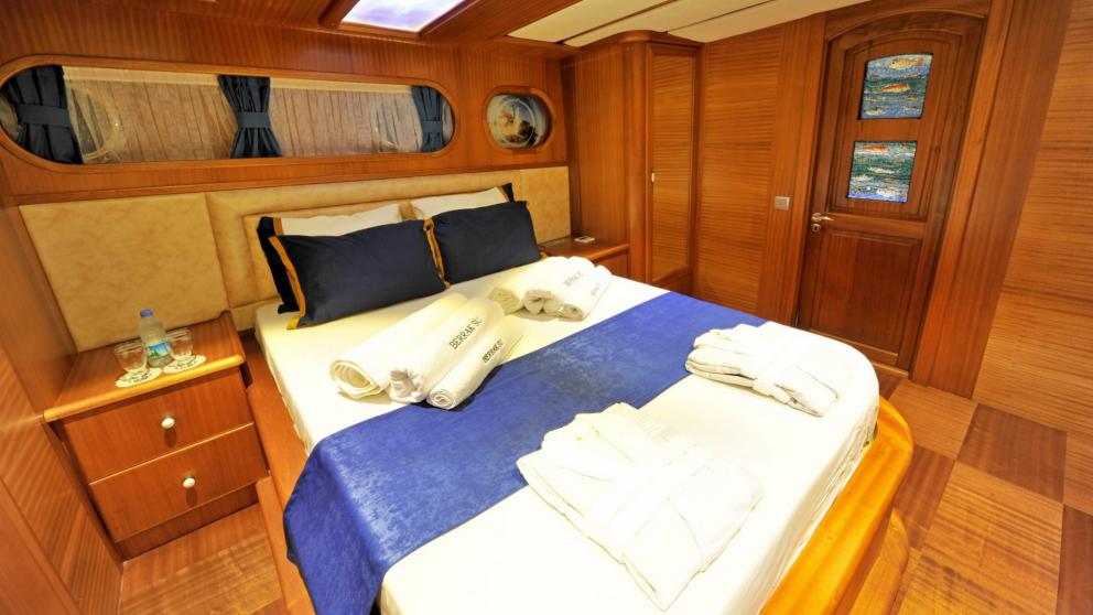 Cosy guest cabin with double bed and blue accents on the gulet Berrak Su.