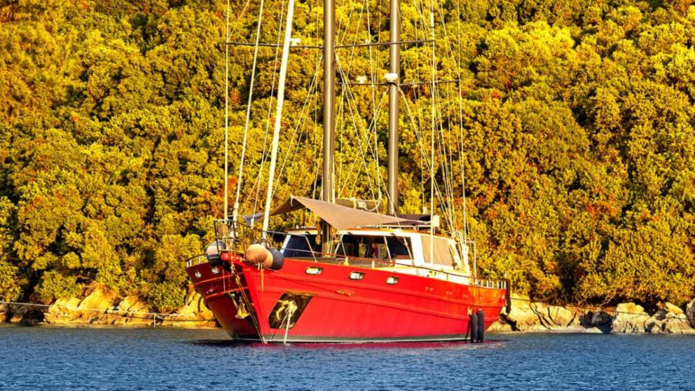 Sailing Gulet ist Segeln auf dem Meer in einem Ziel mit üppigen grünen Bäumen.