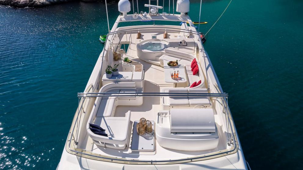 Elegant flybridge with hot tub and seating area on a motor yacht in turquoise water