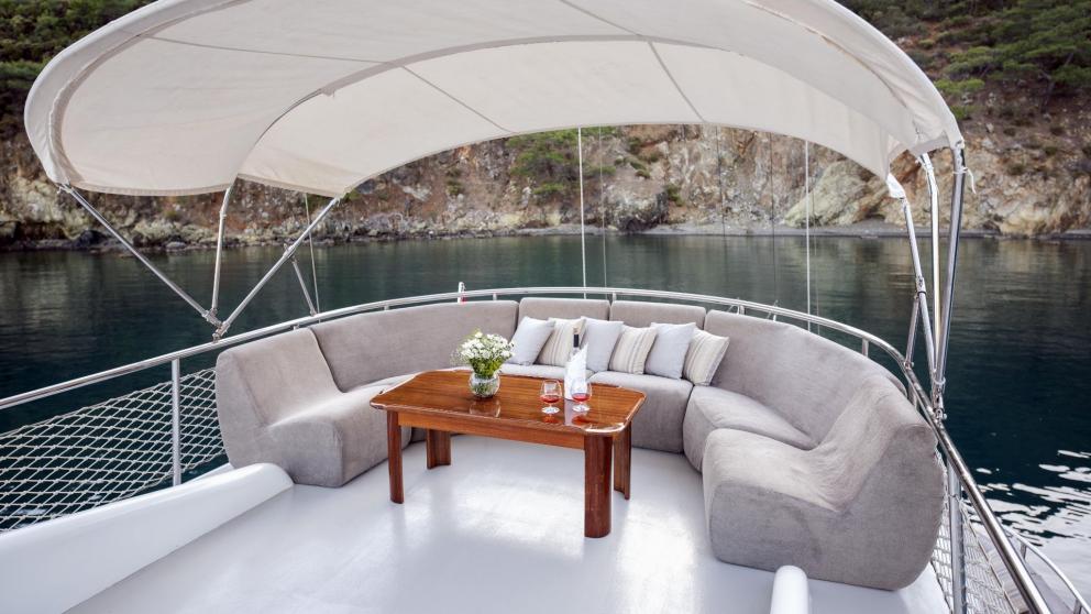 Cosy seating area on a traditional Turkish gulet with five cabins, anchored in the calm waters of Fethiye.