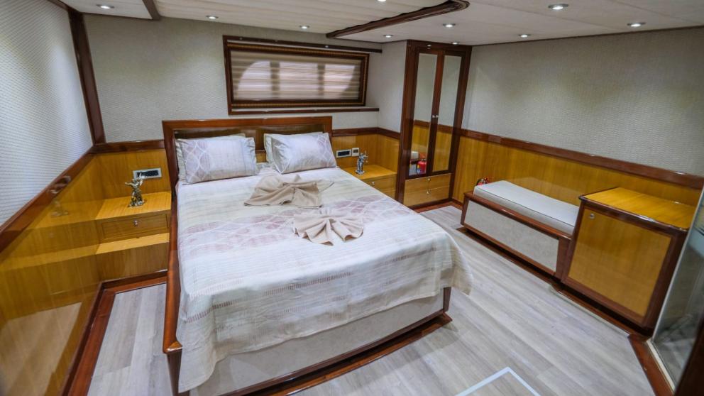 Spacious master cabin with a double bed and seating area on the gulet.