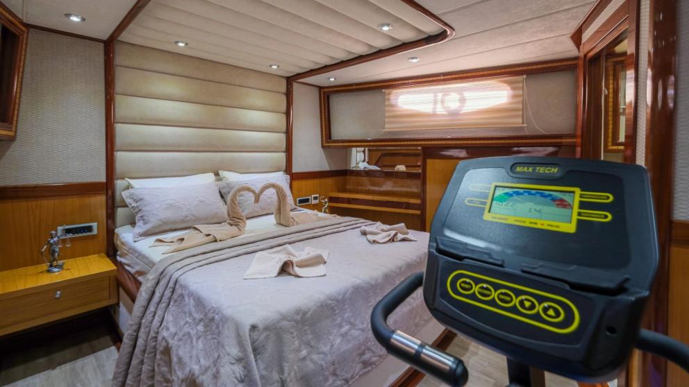 Comfortable cabin with a double bed and fitness equipment on the gulet.