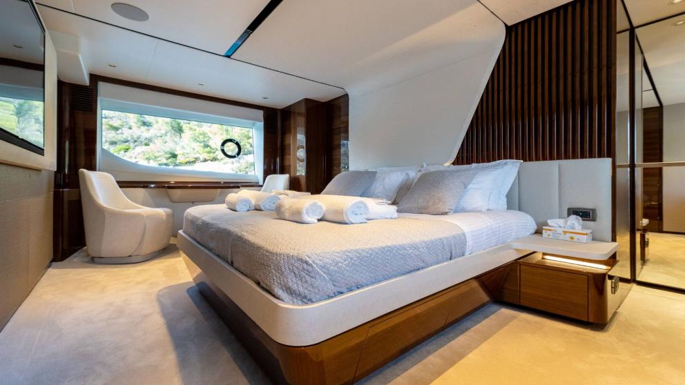 Spacious bedroom with desk and panoramic window on a yacht.