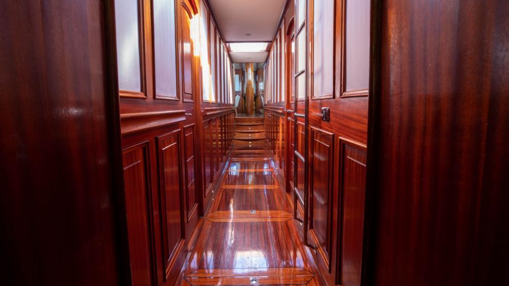 An elegant wooden corridor on board the Gulet Elianora, polished to a shine and fitted with stylish panelling.
