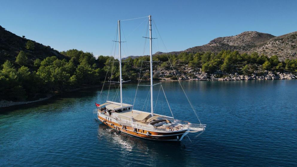 Traditional gulet yacht anchored in a quiet, picturesque bay.