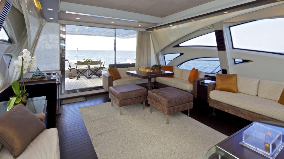 Stylish salon with access to the outer deck, featuring a chessboard and comfortable seating on the motor yacht Thea Malt