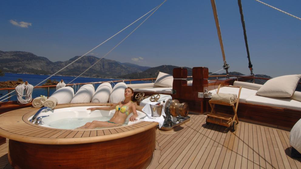 Jacuzzi on the upper deck of the Mare Nostrum gulet and a view of the majestic mountains