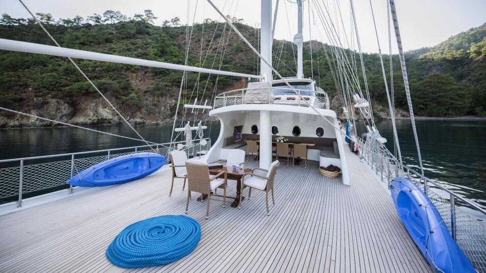 View of the spacious deck of a traditional Turkish gulet with five cabins, anchored in the calm waters of Fethiye.