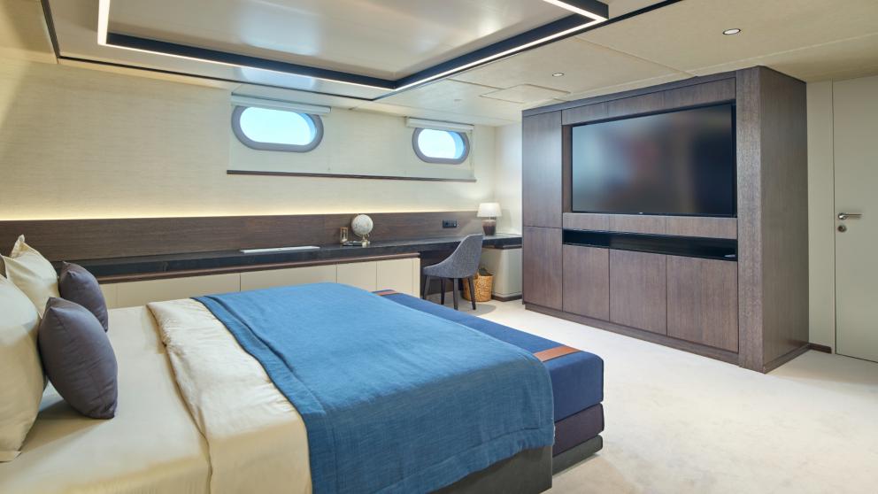 Modern master cabin of Anima Maris with a large bed, TV, and desk, perfect for relaxing.