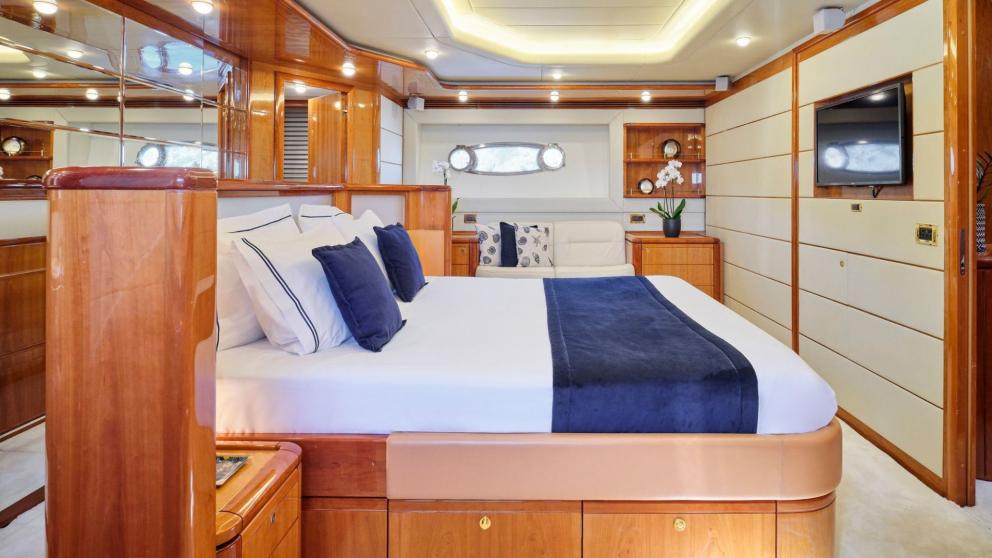 Luxurious bedroom on a yacht with a large bed, stylish interior, and seating area