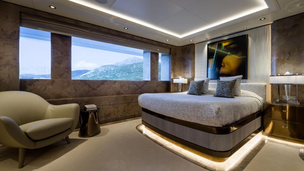 Guest bedroom on the Opari yacht with a large bed, stylish lighting, and sea views.