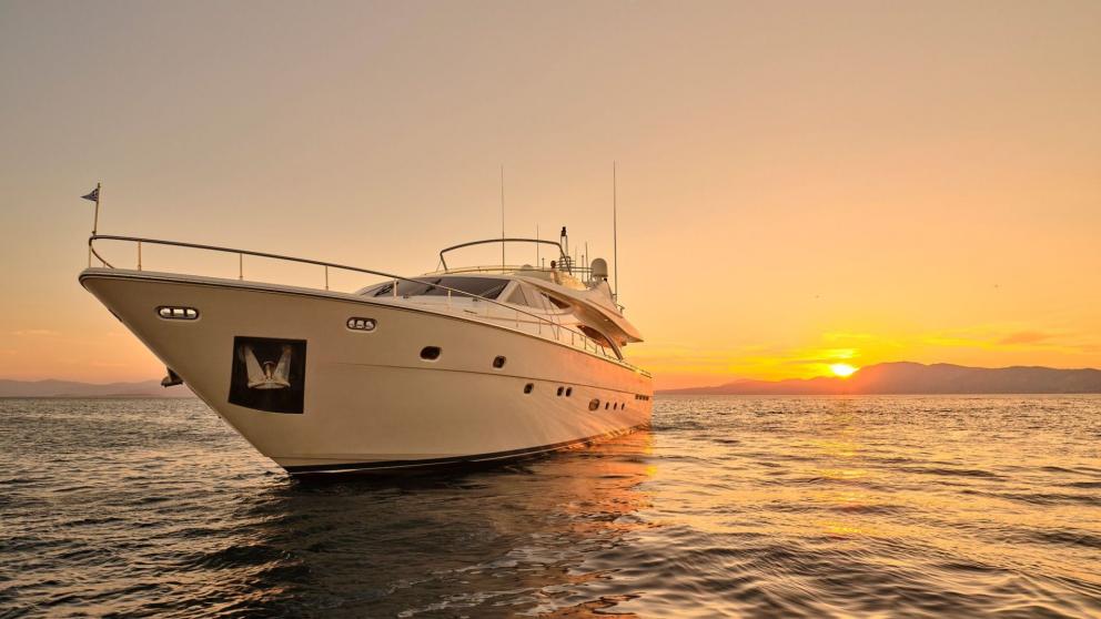 Elegant motor yacht in calm waters at sunset in Greece