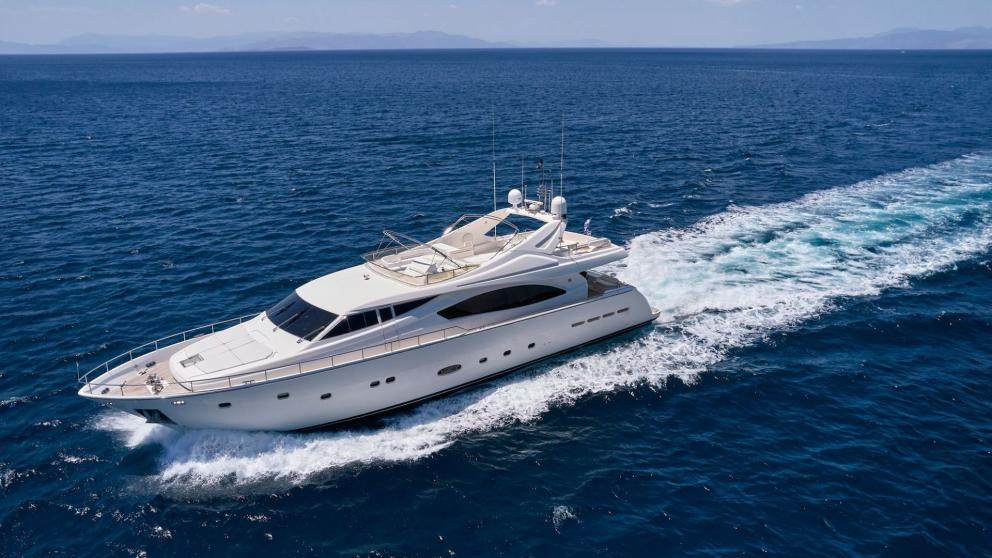A luxurious motor yacht leaves a white wake as it speeds across the vast, open sea.