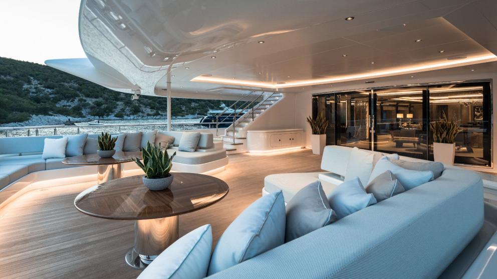 The luxurious lounge on the Opari yacht offers comfortable seating, elegant tables, and stunning views of the Greek coas