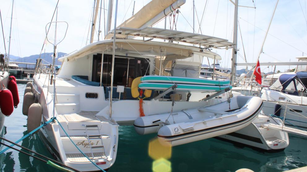 Rear view of charter catamaran with service boat and SUP