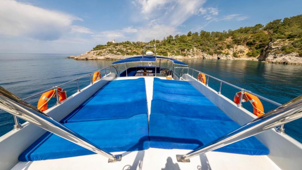 Sun deck of the gulet Enjoy Life with comfortable sunbathing areas and a view of the coast in Fethiye.