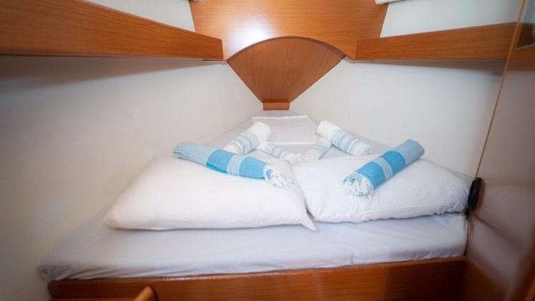 Double bed with snow-white bed linen in the bedroom on the Freya sailboat