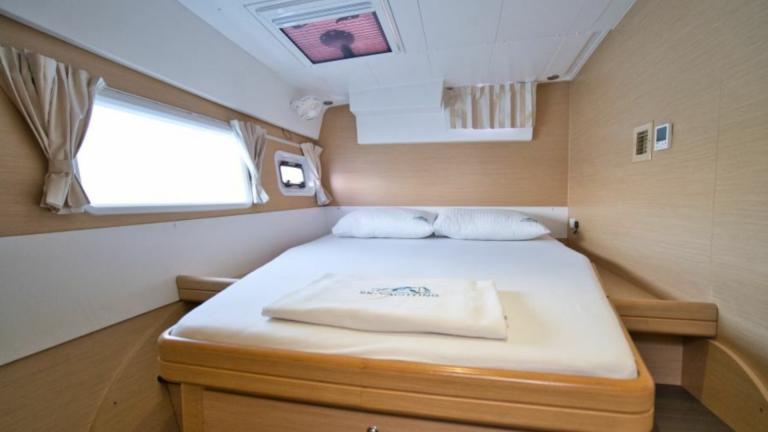 Large window in the bright bedroom on the catamaran Milly