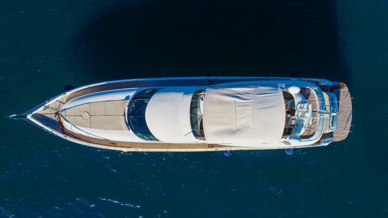A bird's eye view of this modern yacht on still water in the sunshine.