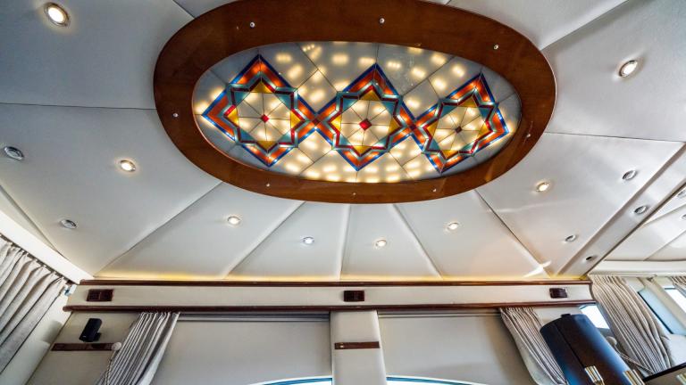 A decorative lamp hangs from the leather-covered ceiling with integrated spotlights.