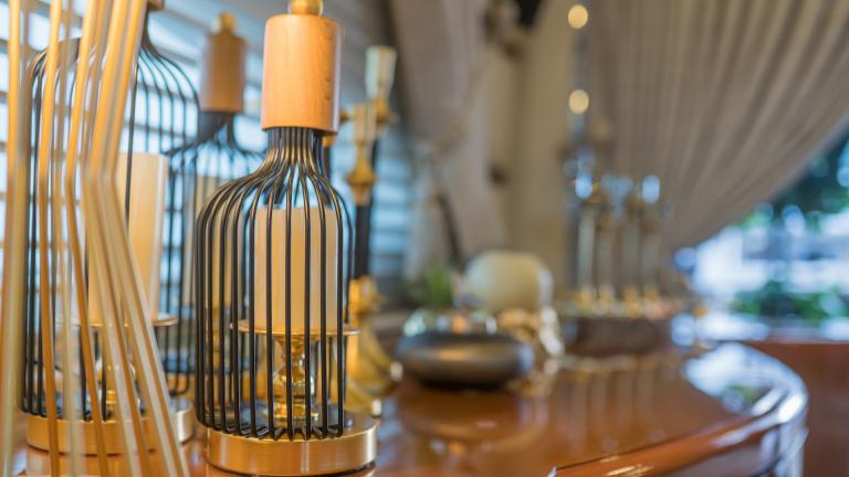 A luxury candle holder in the shape of a bottle on the wooden sideboard of the Viva Lola.