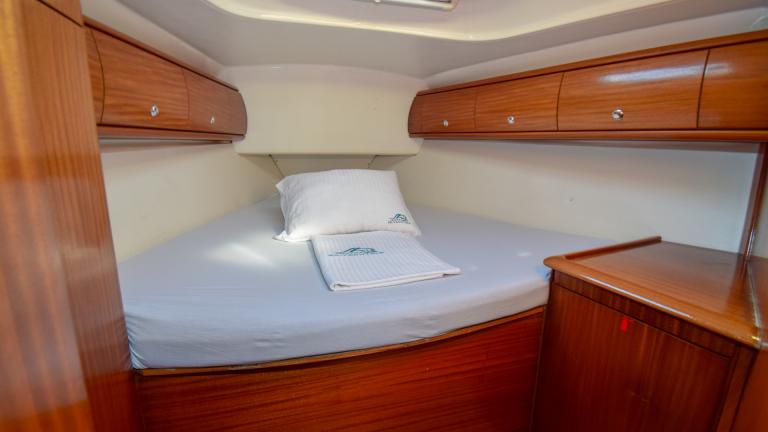 Stateroom with large double bed and storage cupboards for personal belongings