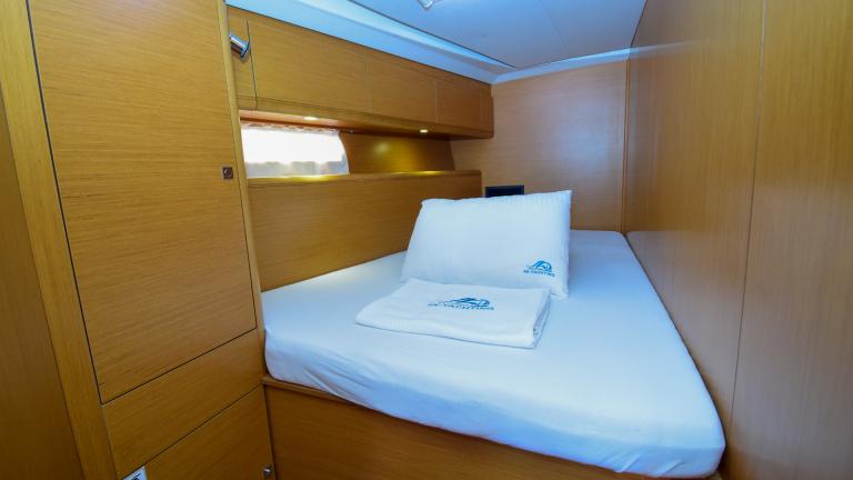 Double bed and wardrobes for storing personal belongings in the cabin
