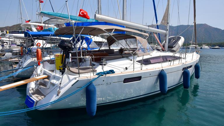 The aft deck of the yacht Anja Sophie docked in the harbor alongside other yachts.