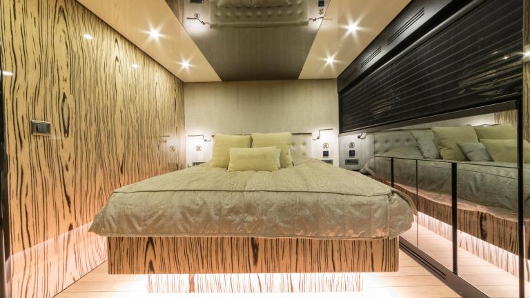 The cozy bedroom of the Emanuel gulet. You can see the big high bed with lights