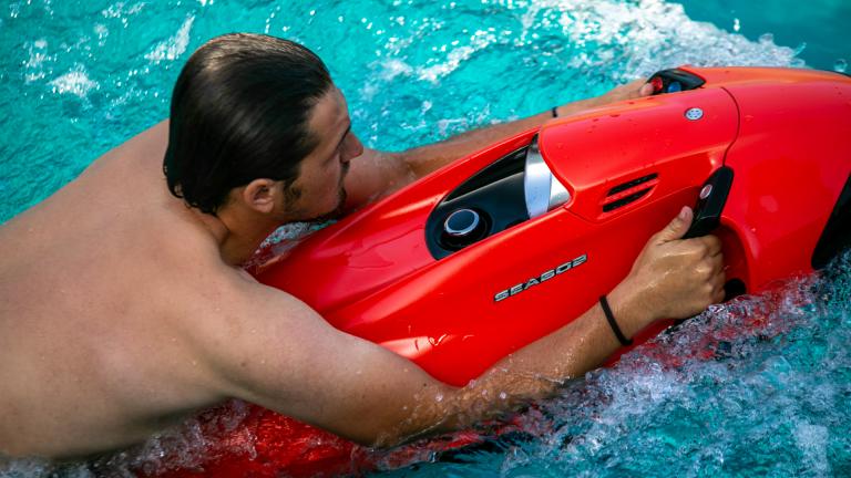 Seabob is the best tech toy for any water surface. A man uses a red Seabob