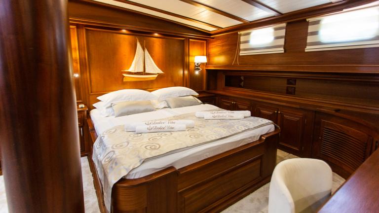Çalışma alanı ile duvarda büyük yatak ve yelkenli resmi olan yatak odasıc