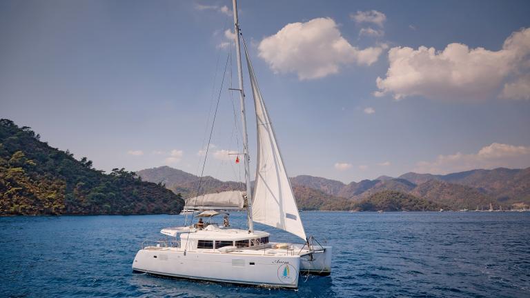 Catamaran Anna in the azure sea. You can see cloudy weather