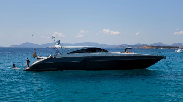 Zazzazu motoryat Ibiza açıklarında demirlemiş. Misafirler paddle board ile denizin tadını çıkarıyor. Kiralık yatla eğlen
