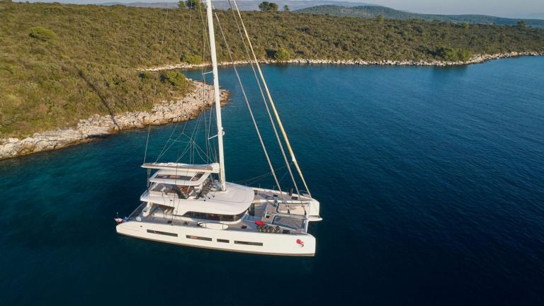 Der Lagoon Katamaran Adriatic Dragon ankert vor einer malerischen Küste in Kroatien.