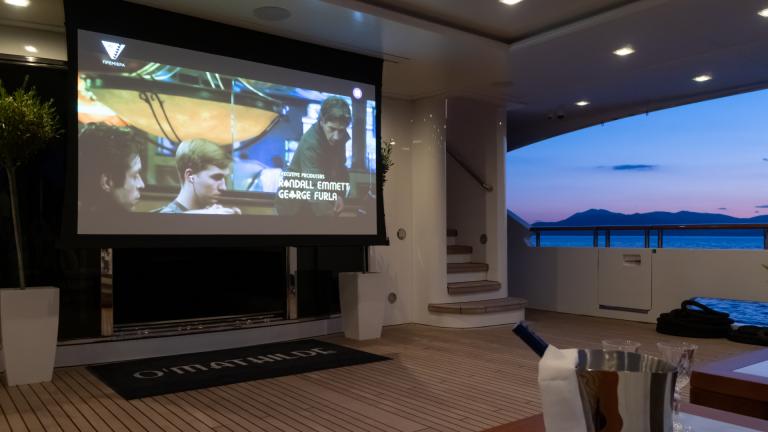 Film evening on the yacht with screen and sea view at sunset. Exclusive and relaxed atmosphere.