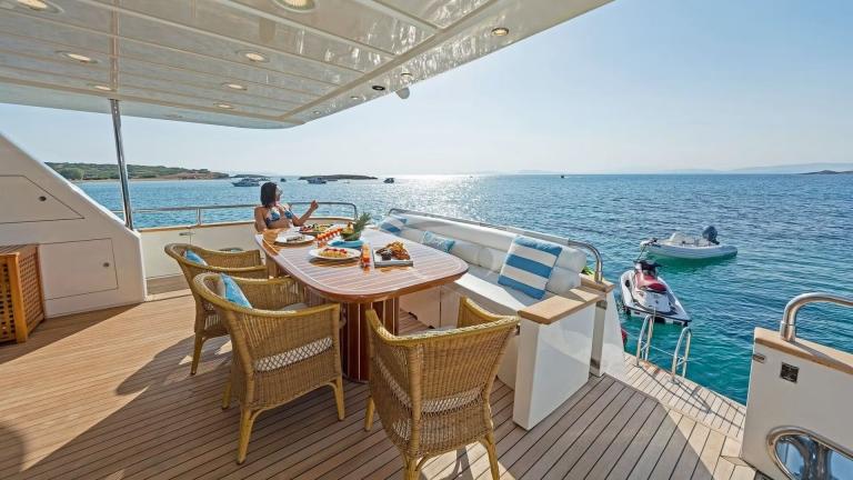 Dining table and seating area on the aft deck of luxury motor yacht Illya F