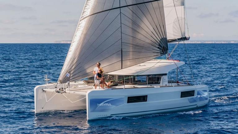 Cruising on the catamaran Hayra with sails unfurled, guests enjoy the view.