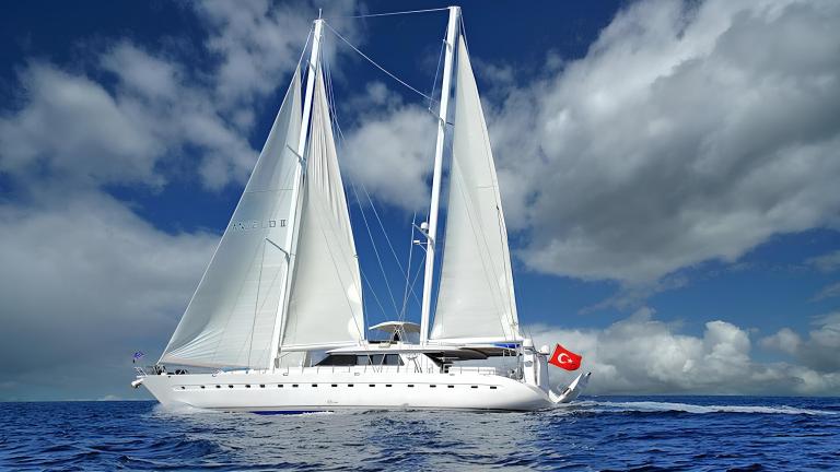 The yacht Angelo 2 gracefully sails with white sails on the open sea.