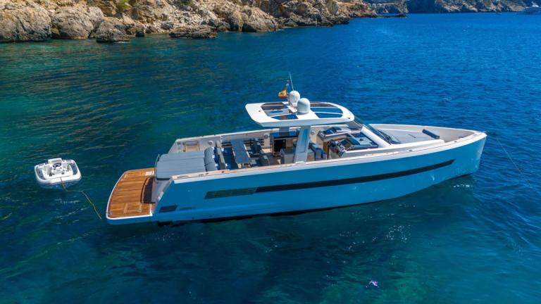 Petitchet motor yacht anchored off Mallorca’s coast in crystal clear waters offering holiday comfort.