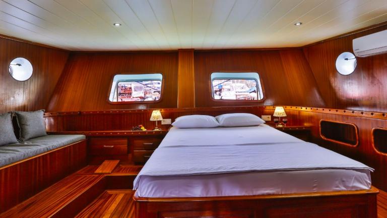 Elegant cabin on the Gulet Victoria with a large bed and wooden furnishings.