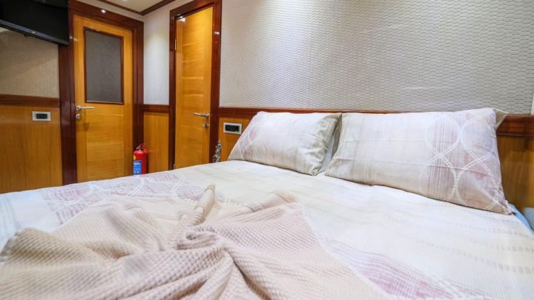 Cozy double bed in a stylishly furnished cabin on the gulet.