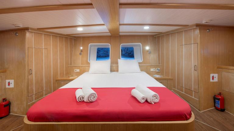 Comfortable cabin with double bed, minimalist furnishings and modern wood panelling.