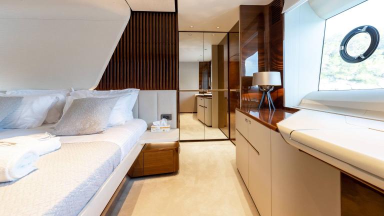 Stylish bedroom with mirrored wall and natural light on a yacht.