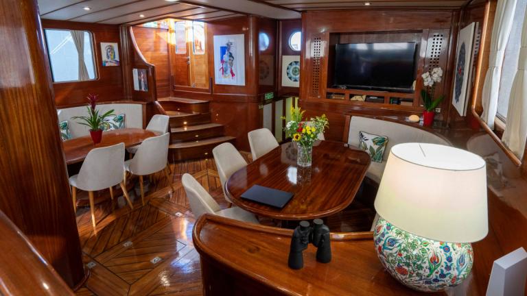 The luxurious saloon of the Gulet Elianora with elegant wooden furniture, comfortable seating, decorations and a televis