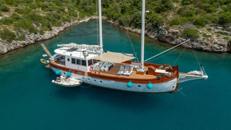 Die Gulet-Yacht Green Ray ankert in einer ruhigen Bucht bei Split. Auf dem Deck sieht man Sonnenliegen, Sonnensegel und