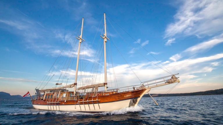 Ein Charter-Gulet mit 6 Kabinen aus Kroatien, segelnd auf dem Meer bei Sonnenuntergang.
