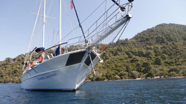 Segelabenteuer auf der Sumru Sultan, eine luxuriöse Gulet vor beeindruckender Küstenlandschaft in Fethiye.