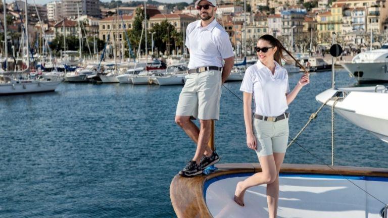 A man and a woman in shorts and white T-shirts are standing on a luxury yacht.