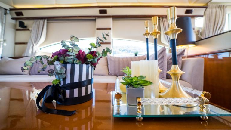 A table decorated with flowers and gilded candlesticks in the lounge area of the luxury yacht.