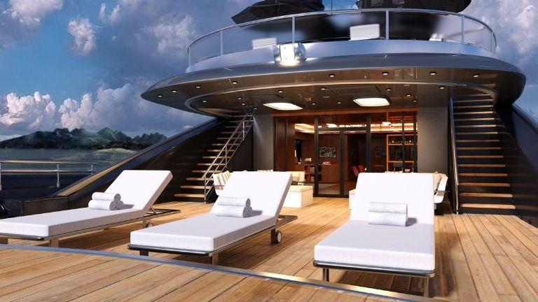 Die glamouröse Yacht steht mit drei weißen Luxus-Sonnenliegen auf dem Deck auf dem Meer.